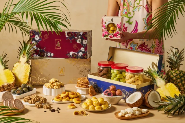 A woman holding a bottle of Ding Bakery goodies beside a festive table